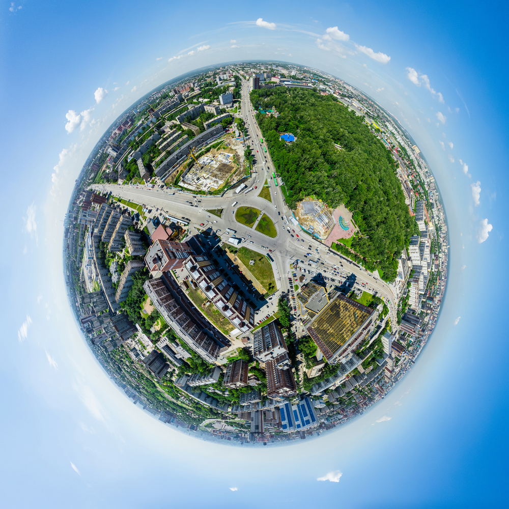 Aerial city view with crossroads and roads, houses, buildings, parks and parking lots, bridges. Urban landscape. Copter shot. Panoramic image.